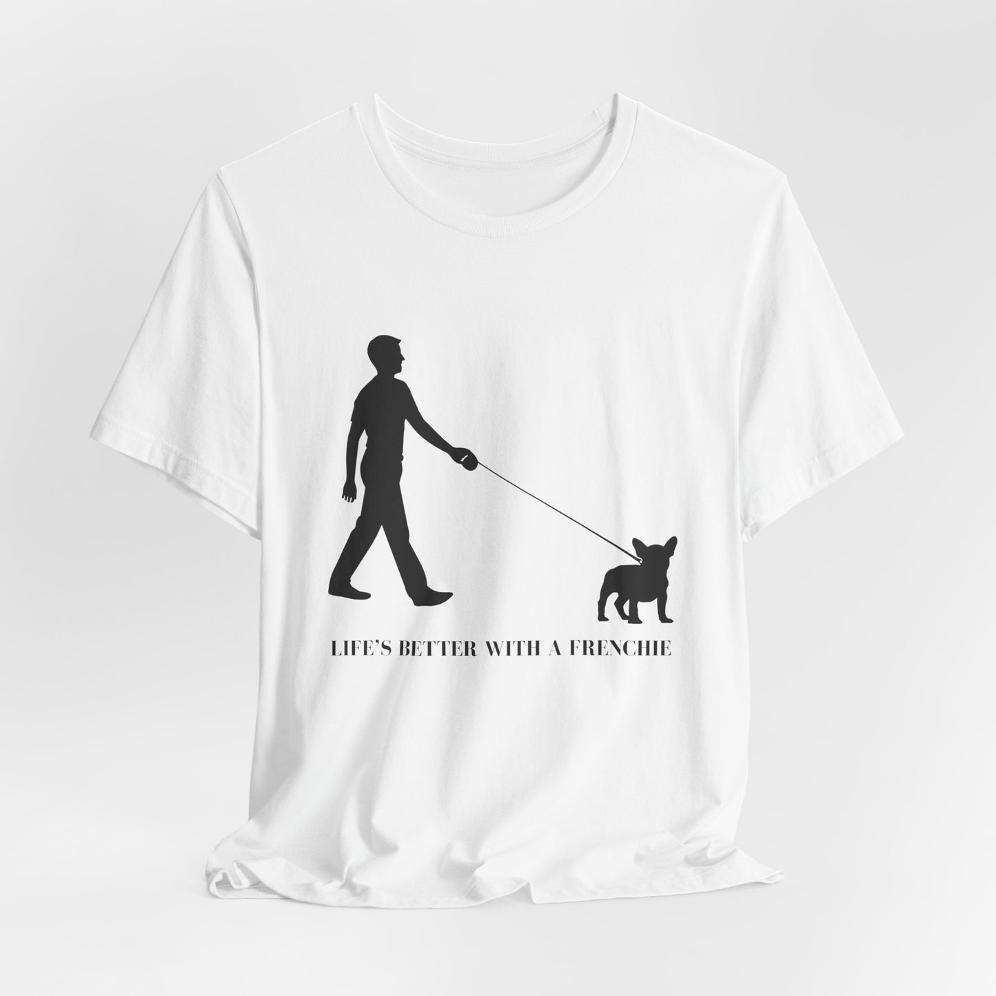 White t-shirt with black graphic of a person walking a dog and text 'Life's better with a Frenchie' on a white background