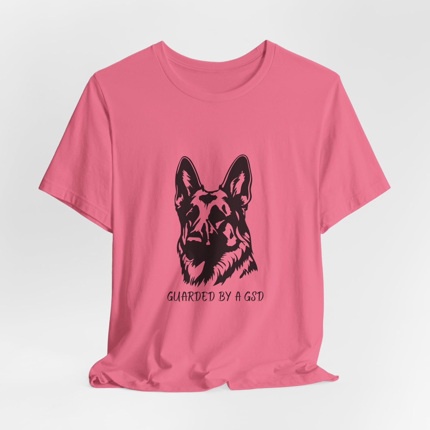 Pink t-shirt with a black dog graphic and text on a white background