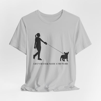 White t-shirt with black silhouette design of a person walking a dog and text 'Life's better with a Frenchie' on a white background.