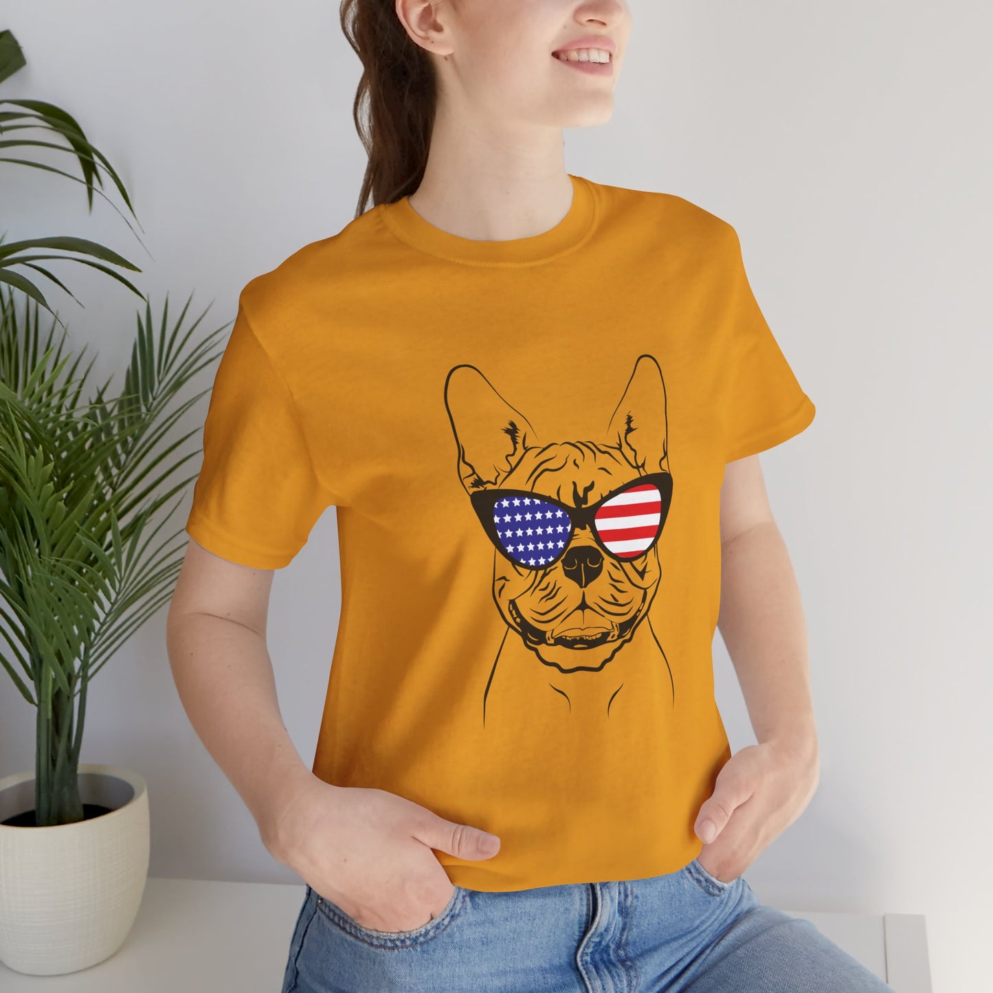 Person wearing a mustard yellow t-shirt with a dog graphic and sunglasses featuring American flag design.