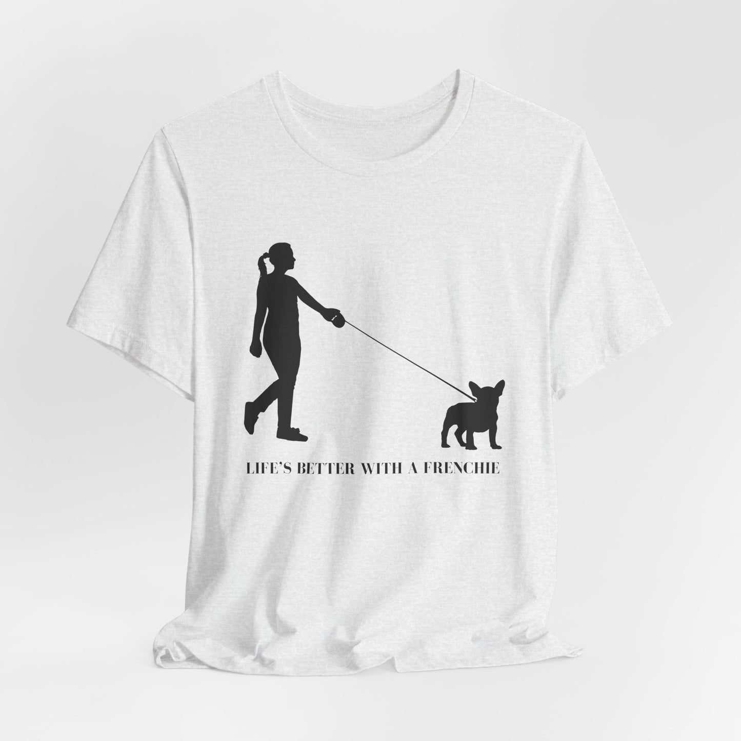 White t-shirt with black silhouette of a person walking a dog and text 'LIFE'S BETTER WITH A FRENCHIE' on a white background
