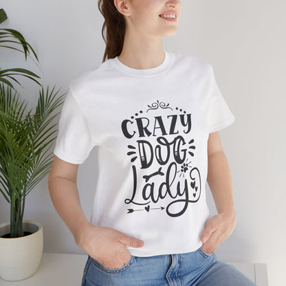 Person wearing a white t-shirt with 'Crazy Dog Lady' text, standing indoors next to a plant.