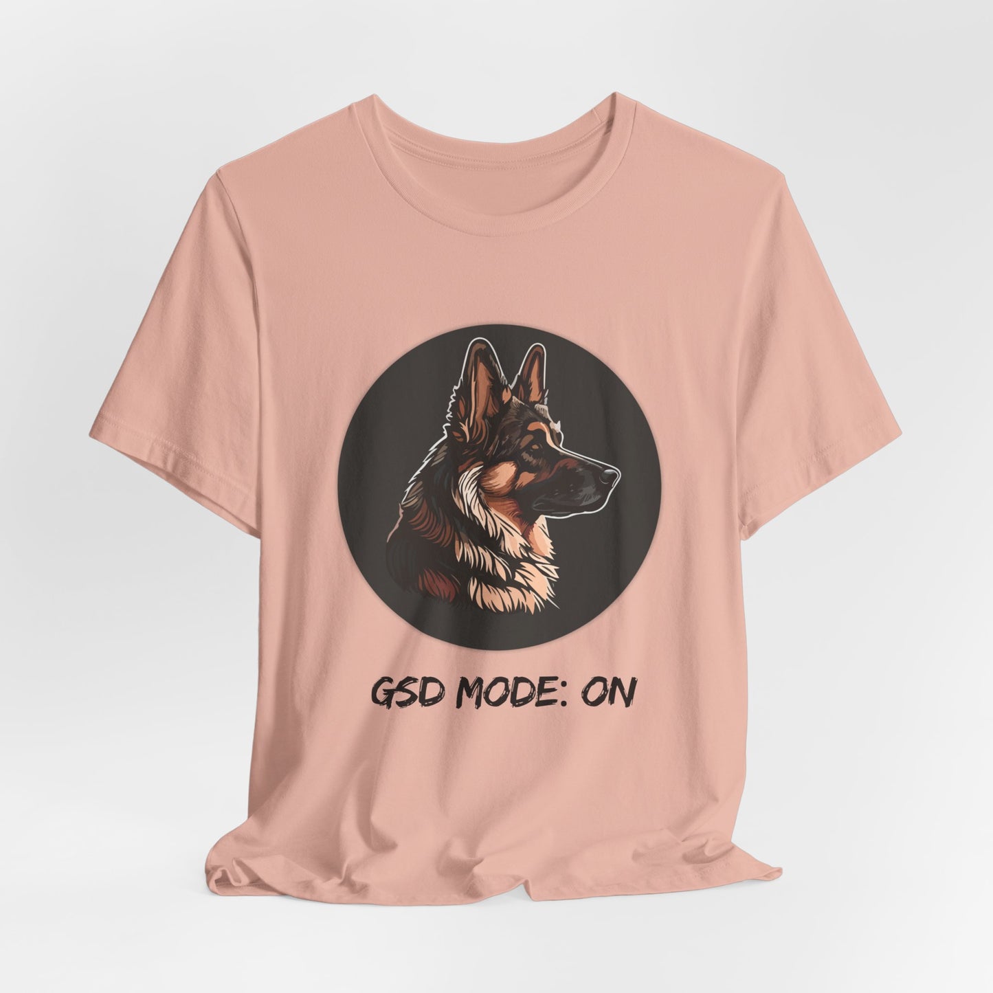 Pink t-shirt with a dog graphic and 'GSD Mode: On' text on a light gray background