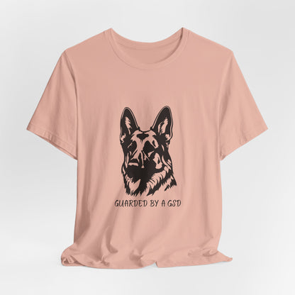 Pink t-shirt with a black dog graphic and text on a light gray background