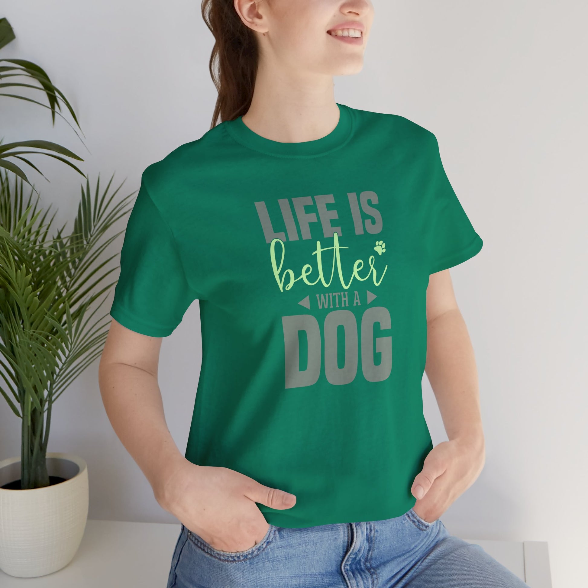 Person wearing a green t-shirt with 'Life is better with a dog' text, standing indoors.