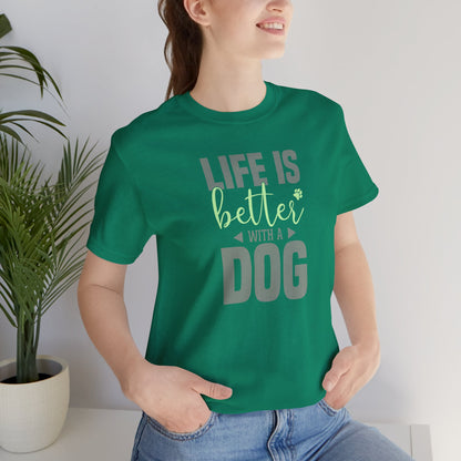 Person wearing a green t-shirt with 'Life is better with a dog' text, standing indoors.