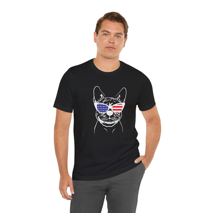 Man wearing a black t-shirt with a graphic design of a dog wearing American flag sunglasses on a white background