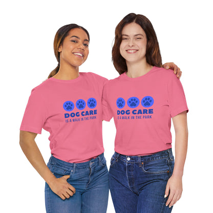 Two people wearing pink t-shirts with 'DOG CARE is a walk in the park' text and paw prints.