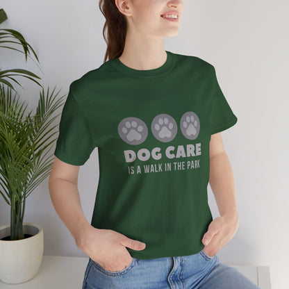Person wearing a green t-shirt with 'Dog Care is a Walk in the Park' text and paw prints.