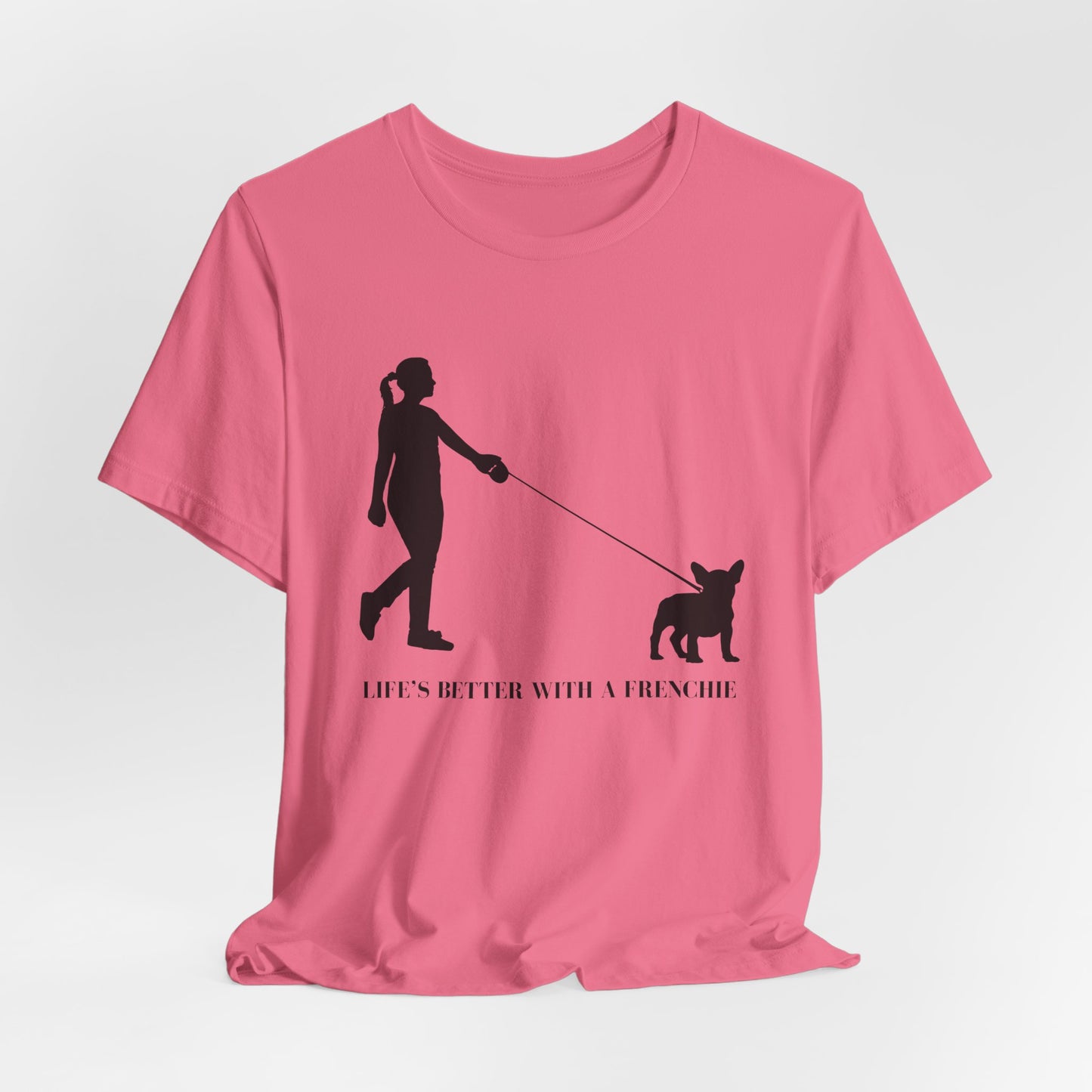 Pink t-shirt with a black silhouette of a person walking a dog and text 'Life's better with a Frenchie' on a white background.