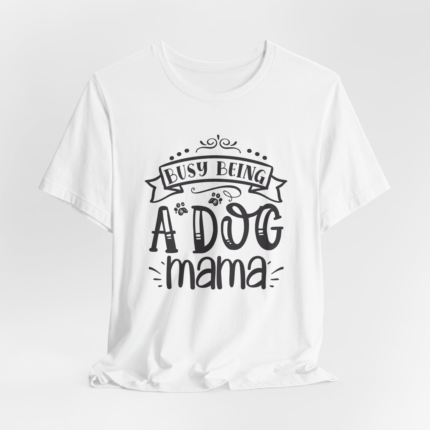 White t-shirt with 'Busy Being A Dog Mama' text on a light gray background